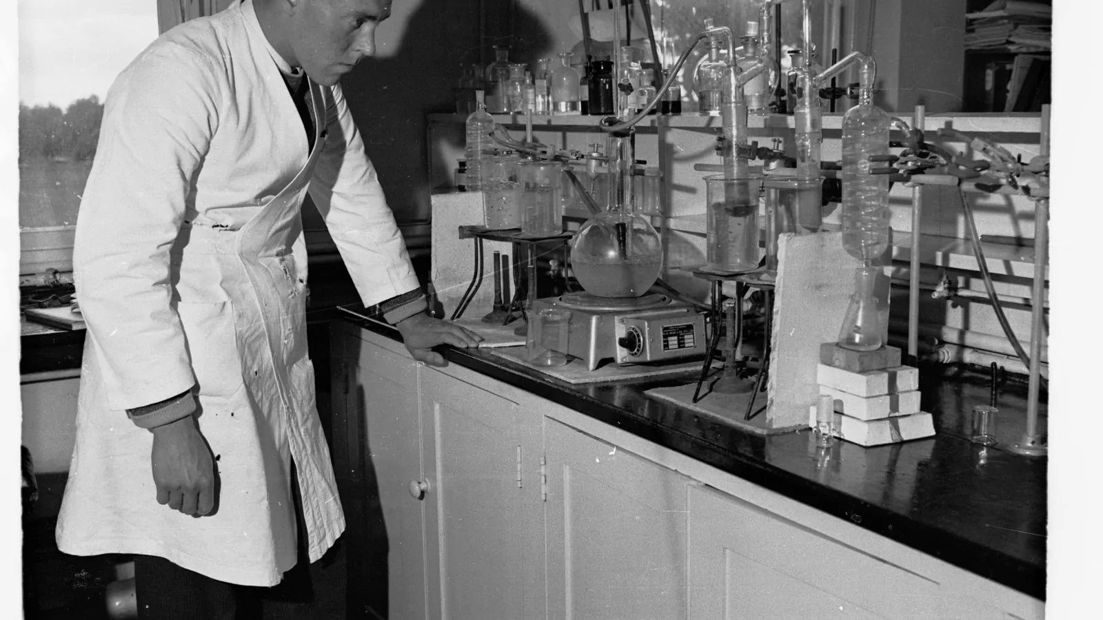 A chemist at a laboratory bench of glass distillation apparatus, 1945